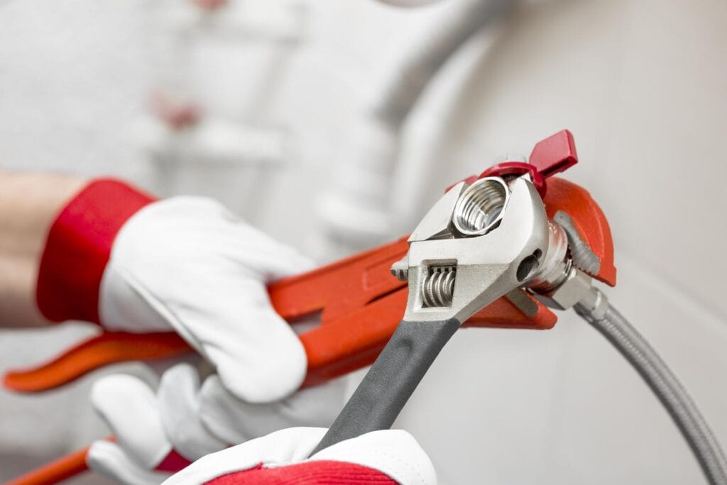 Plumber holding pipe wrenches for an emergency repair in Winter Garden