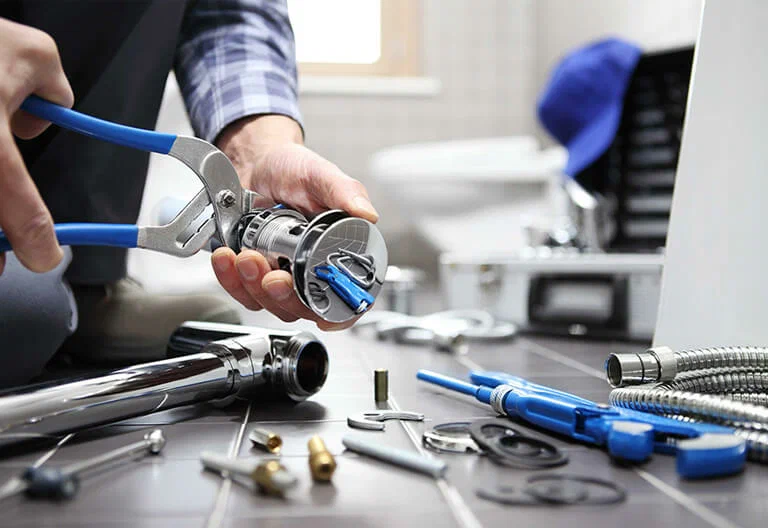Technician repairing a plumbing fixture with professional tools in Winter Garden