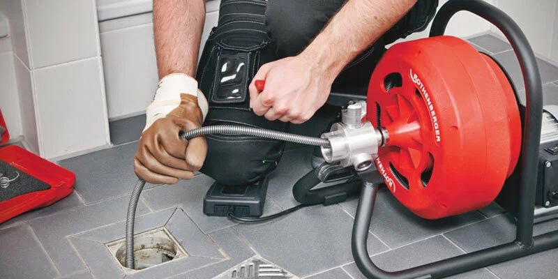Plumber using a drain-cleaning machine in Winter Garden